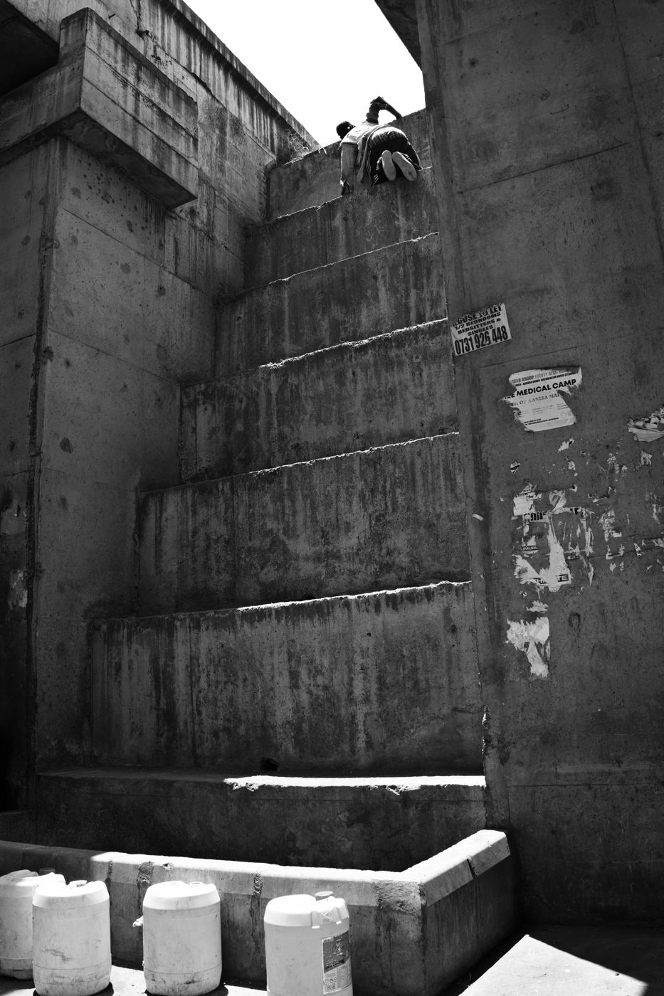 A man climbing a concrete stairway beside a highway