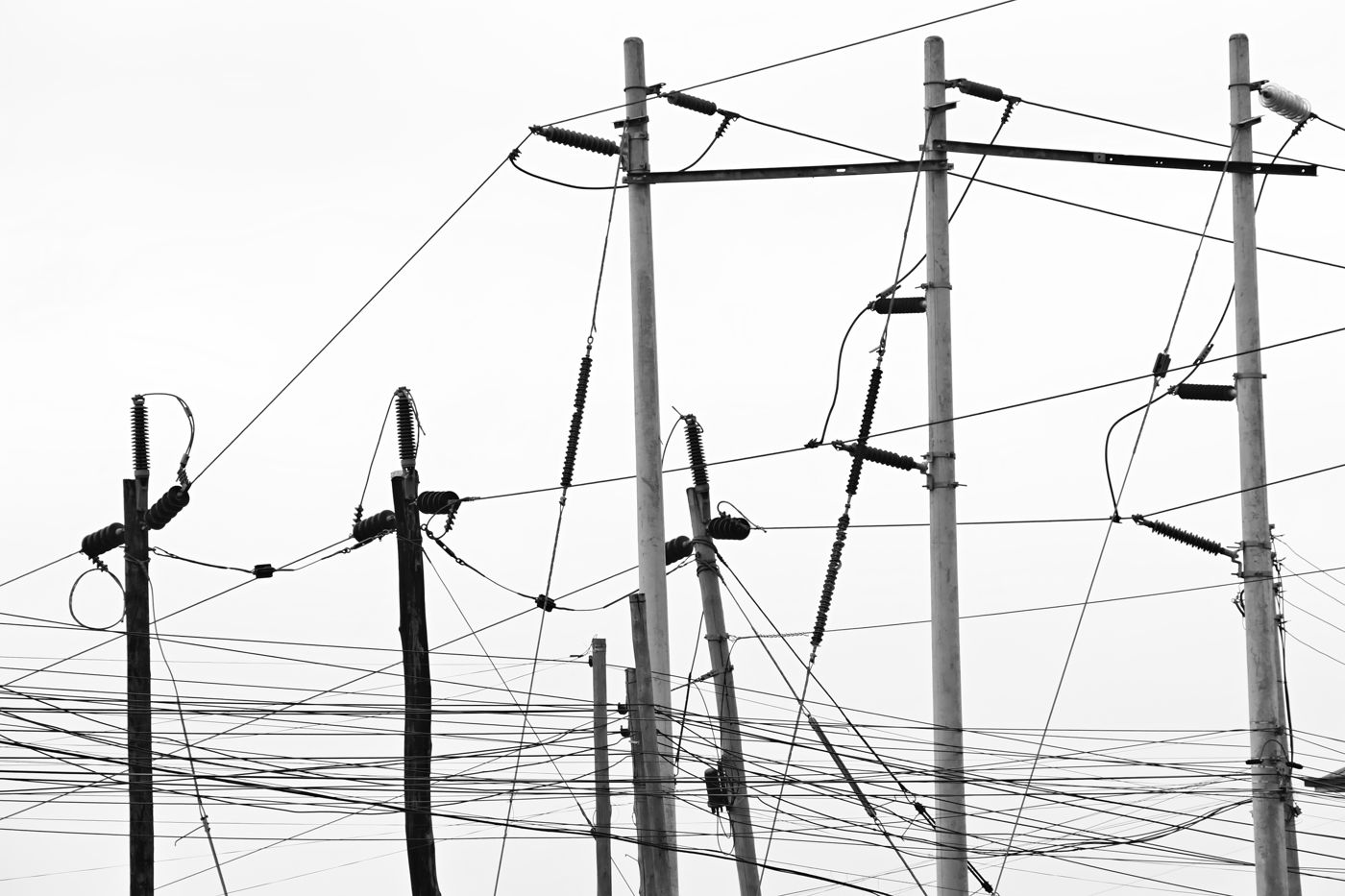 Power lines and poles against a pale sky